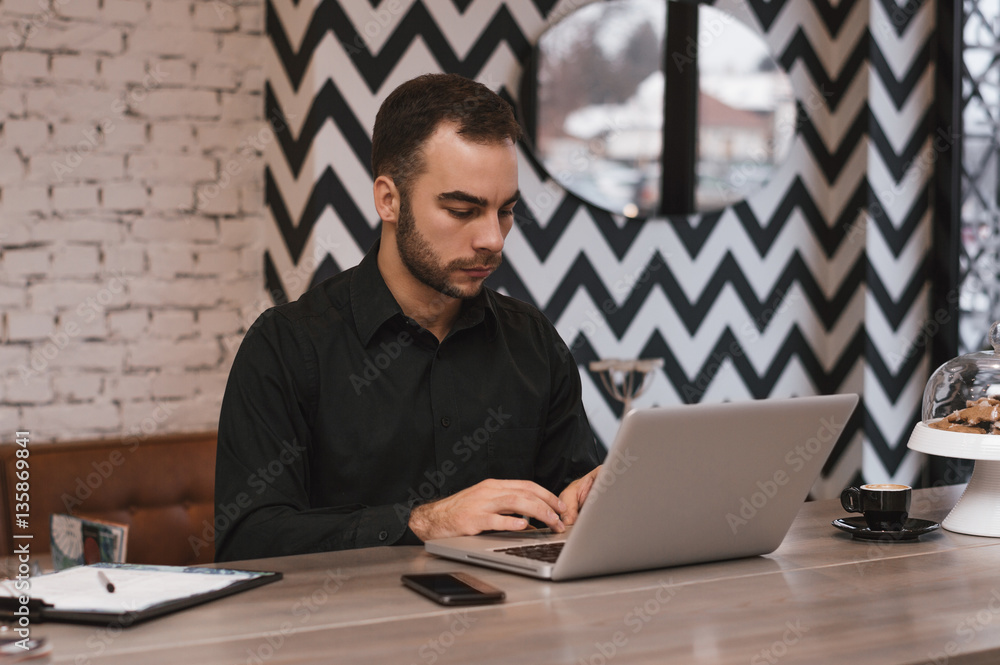 Successful freelancer working on laptop computer in modern inter Successful freelancer working on laptop computer in modern inter