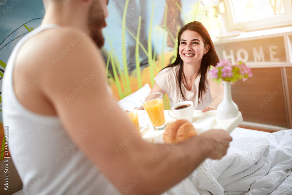 Girl takes tray with breakfast from boyfriend Girl takes tray with breakfast from boyfriend