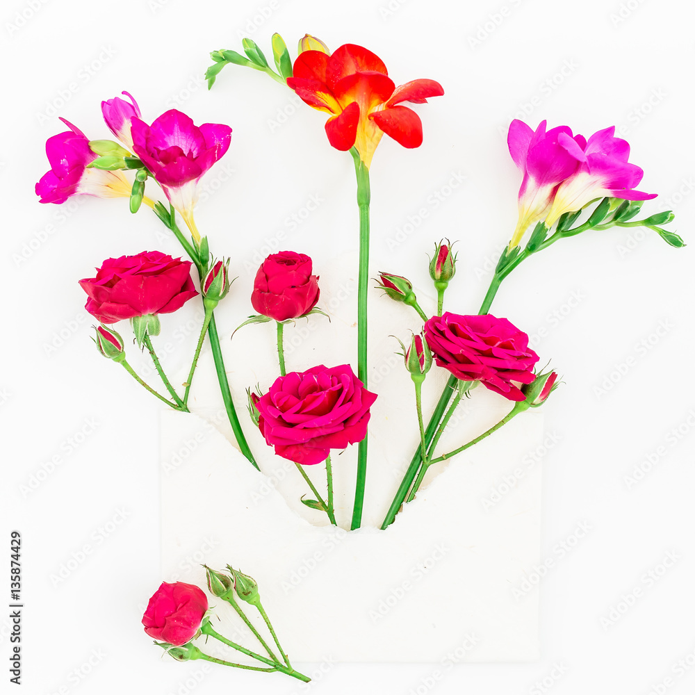 Pink and red freesia, roses and vintage paper envelope isolated on white background, Flat lay, Top view