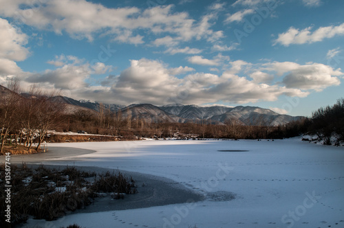 Fototapeta Naklejka Na Ścianę i Meble -  Landscape with a frozen duck lake and mountains of big Caucasus at Sheki, Azerbaijan