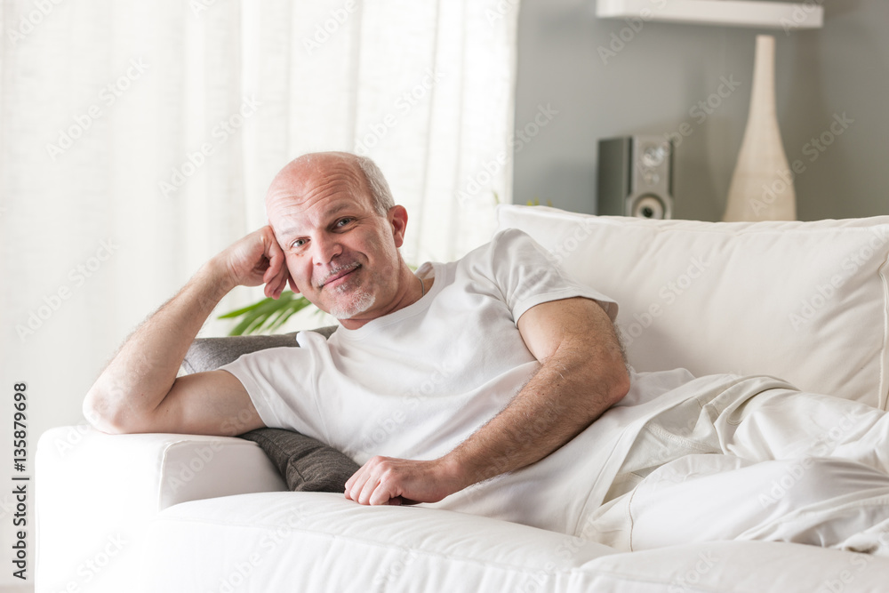 senior man smiling satisfied on his couch senior man smiling satisfied on his couch