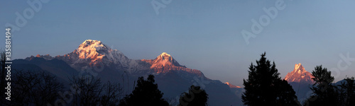 Wild nature, beauty and grandeur. Panorama of amazing peaks and passes of the Himalayan mountain range lit with first light of sunshine at sunrise. Calm and peaceful winter evening in mountains