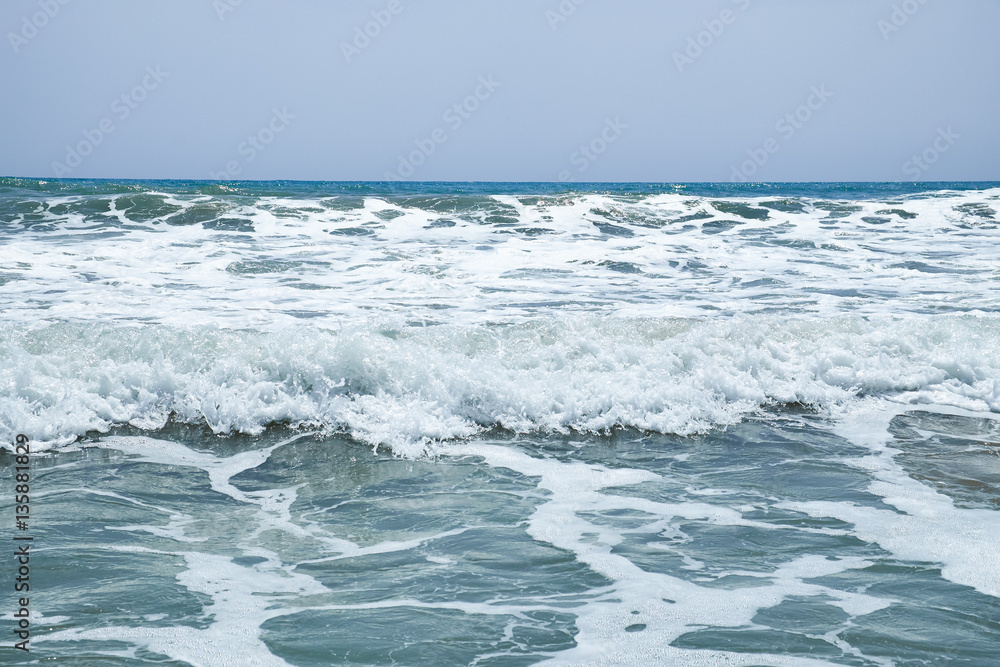 The surging waves of the Mediterranean on the beautiful beach Valencia in the summer sunny day. The surging waves of the Mediterranean on the beautiful beach Valencia in the summer sunny day.