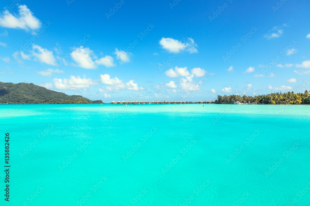 Stunning view of blue turquoise lagoon and far bungalows on back Stunning view of blue turquoise lagoon and far bungalows on back