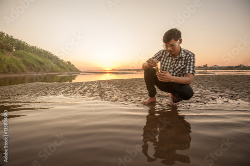 Scientist or biologist working on water analysis near the river. photo
