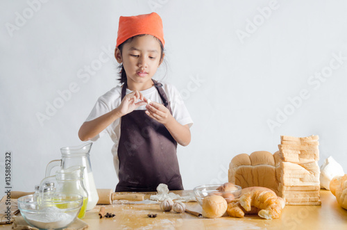 Portrait of Asian little girl holding dough in hand with copy sp