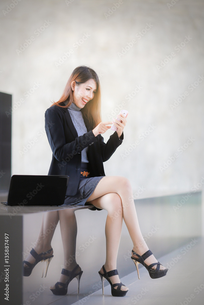 Asian people business woman sit down on the balcony, The beautiful business women hold telephone and smiling , space background for texture Asian people business woman sit down on the balcony, The beautiful business women hold telephone and smiling , space background for texture