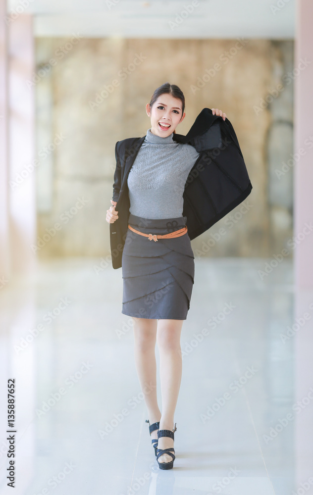 Asian people young businesswoman standing, The beautiful model business women hold suit and smiling Asian people young businesswoman standing, The beautiful model business women hold suit and smiling