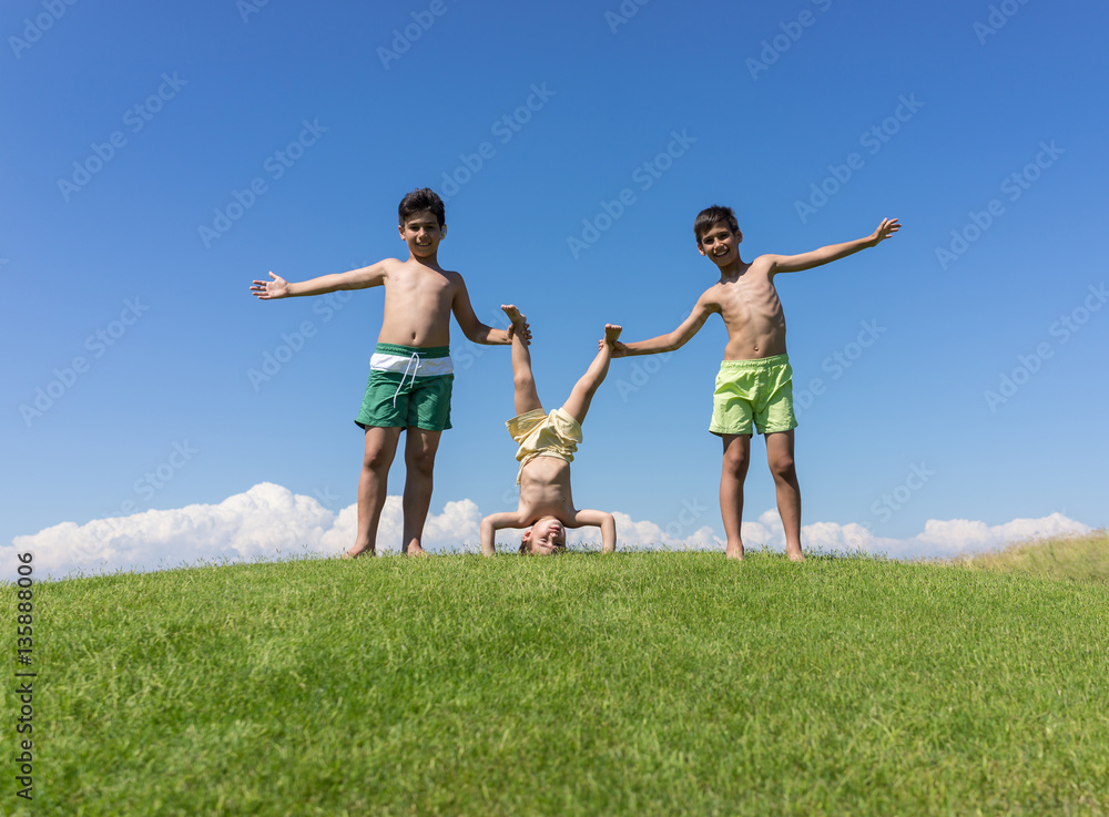 Brothers playing upside down on green meadow Brothers playing upside down on green meadow