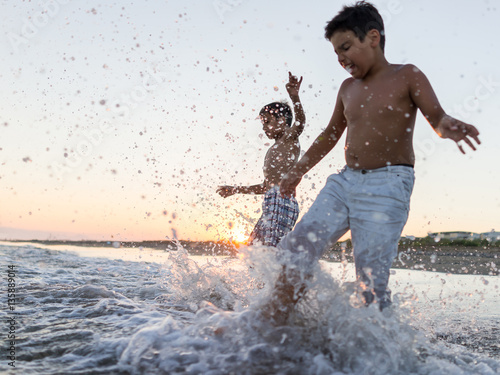 Fun kids playing splash at beach