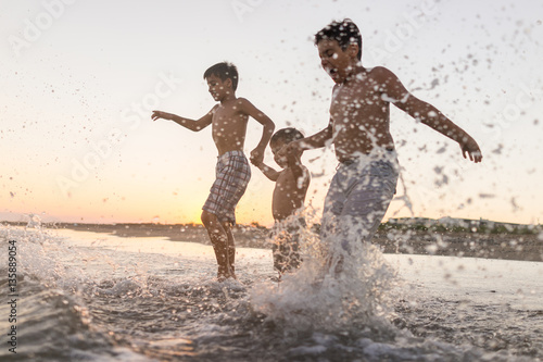 Fun kids playing splash at beach © Jasmin Merdan