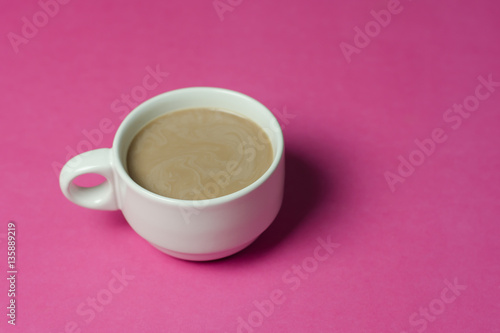 hot chocolate in a ceramic cup on pink paper background