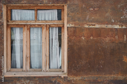 Old rustic wooden window and brown grungy wall. Copy space