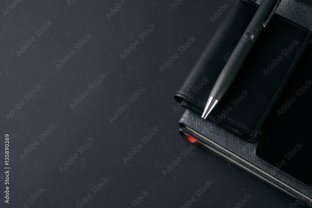 Close up of gentleman set. Magnifying glass, mobile phone, notebook, pen on dark background. Copy space Close up of gentleman set. Magnifying glass, mobile phone, notebook, pen on dark background. Copy space