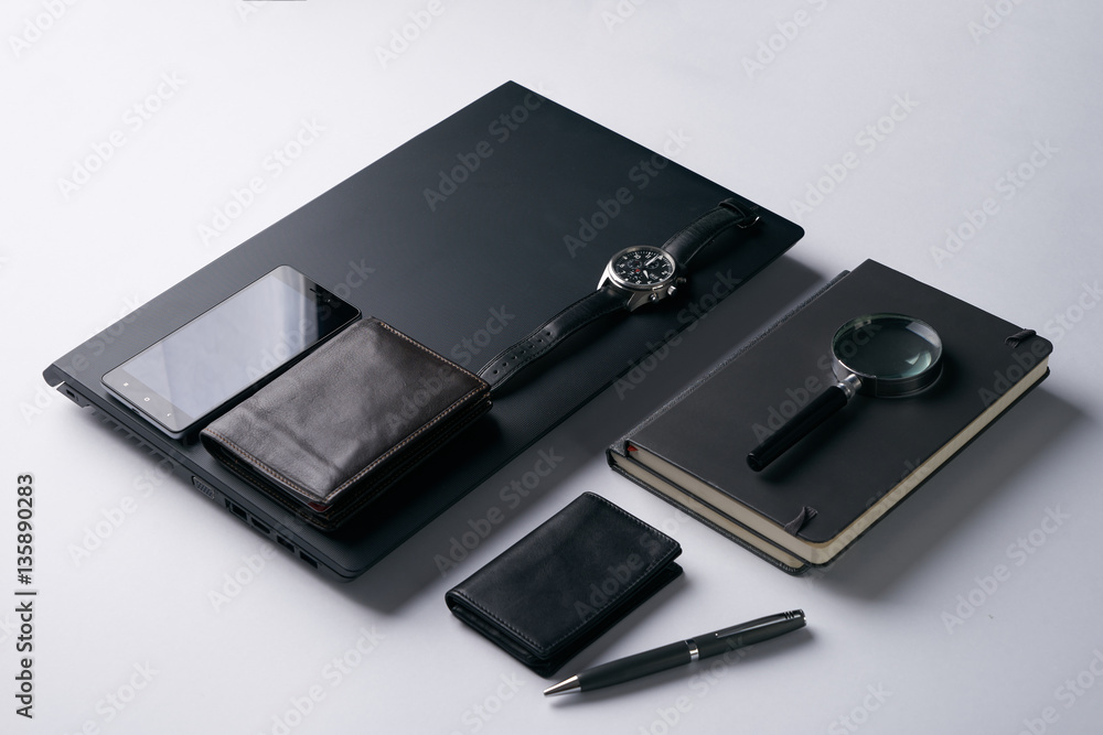 Gentleman set. Magnifying glass, mobile phone, notebook, pen, watch, purse on dark background. Copy space Gentleman set. Magnifying glass, mobile phone, notebook, pen, watch, purse on dark background. Copy space