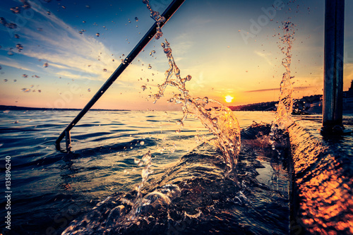 Sunset With Waves Splashing Against Concrete Steps photo