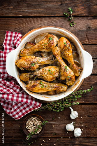 Roasted chicken legs on rustic wooden background, top view
