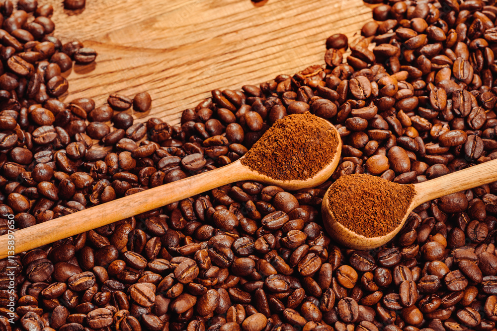 Fototapeta premium Coffee beans and spoons on wooden background