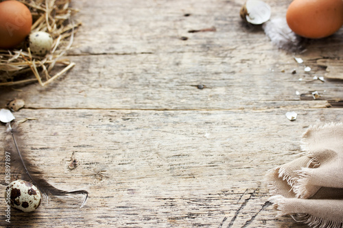 Rustic Easter background with quail and chicken eggs in straw nest