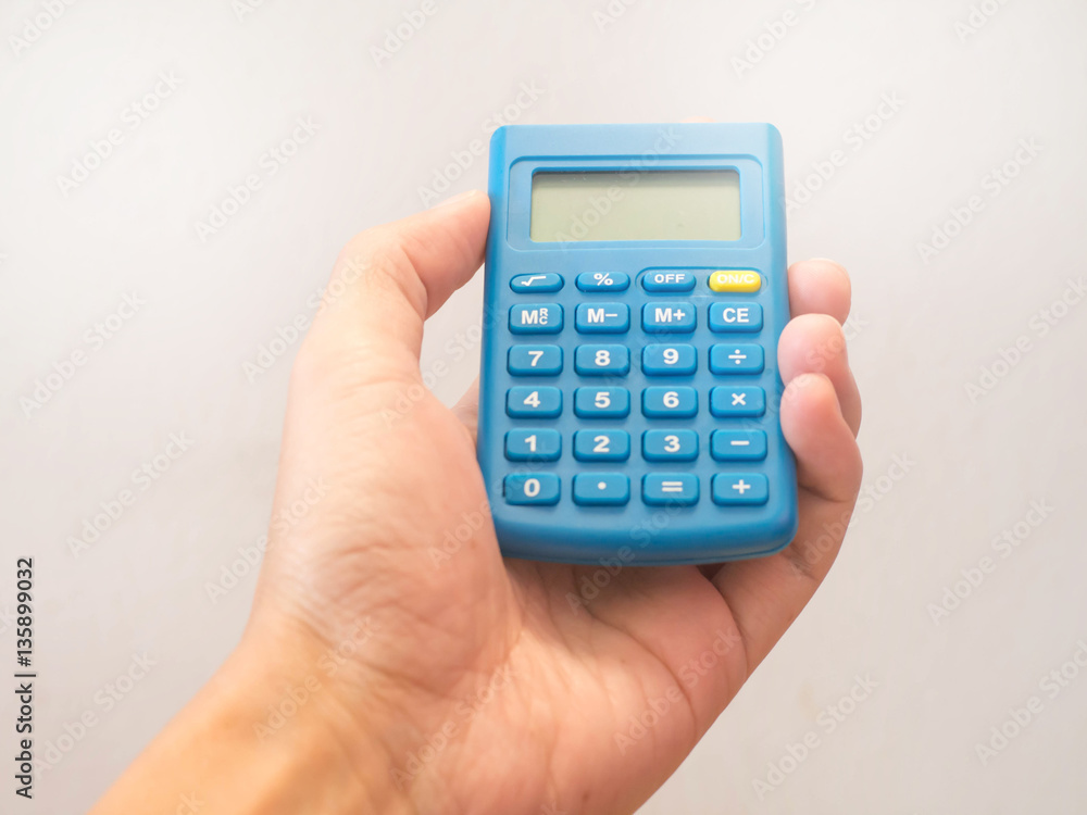 Hand holding blue calculator Hand holding blue calculator