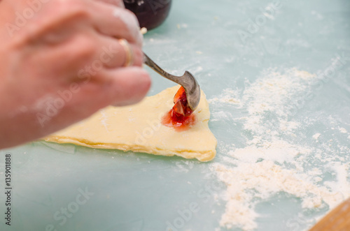 Fototapeta Naklejka Na Ścianę i Meble -  Girl makes homemade cinnamon buns, sliced rolls of dough roll. View from above, hands in picture