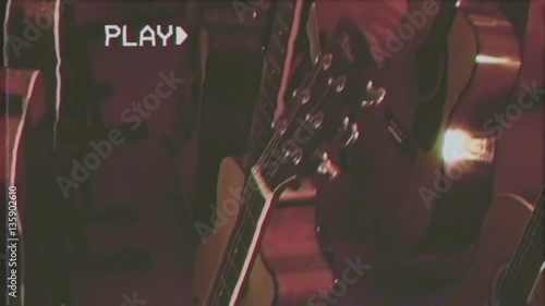 VHS retro fake shot: a guitar shop with many acoustic guitars.
