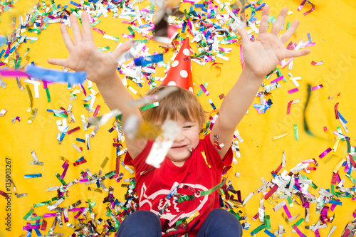 Happy kid celebrating party with blowing confetti top view
