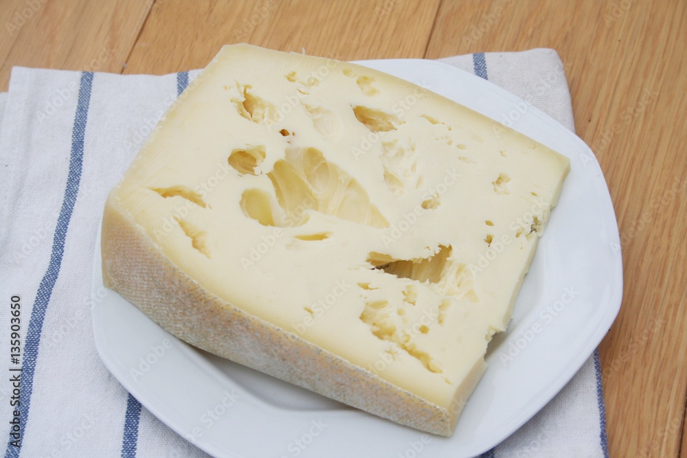 Fetta di formaggio su piatto su tavolo di legno