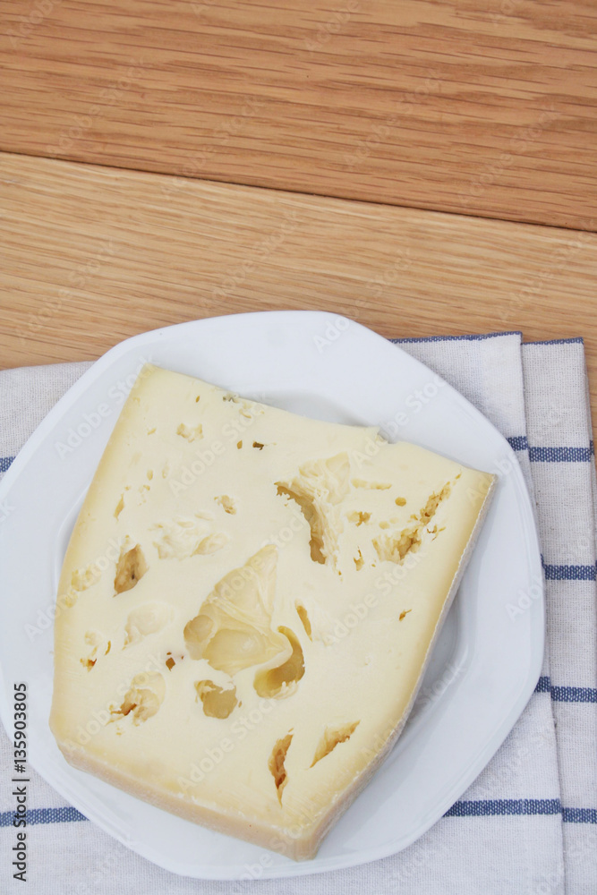 Fetta di formaggio su piatto su tavolo di legno