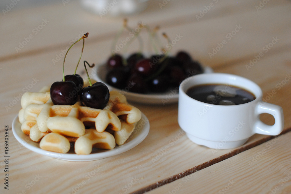Waffles, cherry and coffee on the wooden table Waffles, cherry and coffee on the wooden table