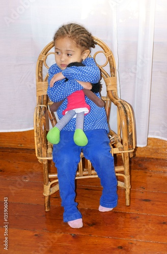 Tableau sur toile sad child sulking and cuddling her dolly