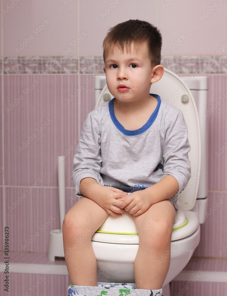 Little boy sitting in the bathroom on the toilet room Stock Photo