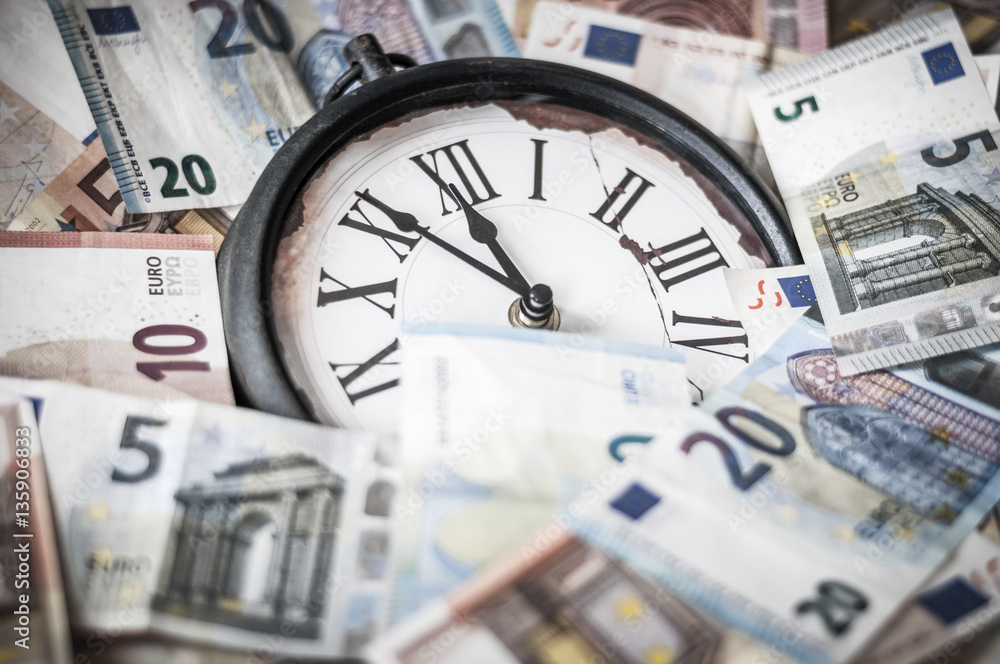 Fuenf Minuten vor zwoelf Uhr / Euro Geldscheine und eine Uhr, die Zeiger stehen fuenf Minuten vor zwoelf. Fuenf Minuten vor zwoelf Uhr / Euro Geldscheine und eine Uhr, die Zeiger stehen fuenf Minuten vor zwoelf.