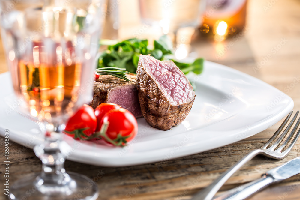 Beef Steak. Juicy beef steak. Gourmet steak with vegetables and glass of rose wine on wooden table.