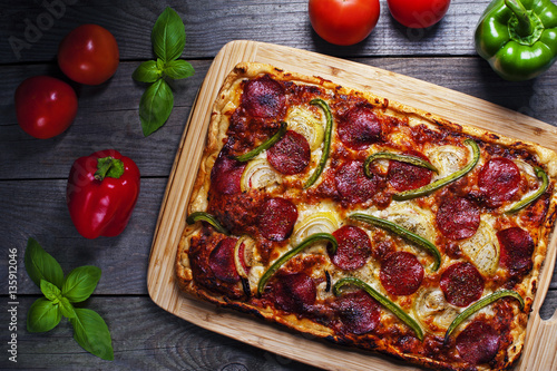 Italian homemade pizza with pepperoni on a wooden table