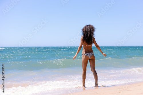 Sexy back of beautiful sporty girl in bikini on summer outdoor beach sky background