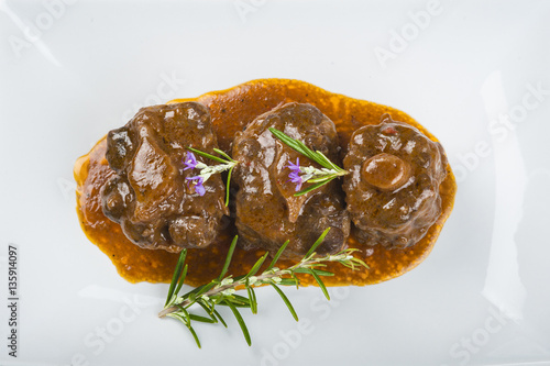 Rabo de toro o ternera en salsa de romero decorado con flores, carne roja para una comida saludable photo