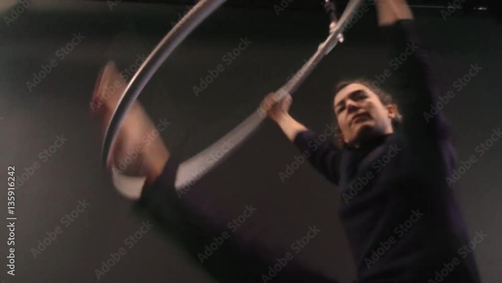 Mujer acróbata girando en el aro aéreo, chica bailarina actuando en el teatro