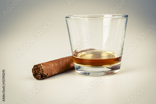 expensive drink of whisky or rum with cigar on white