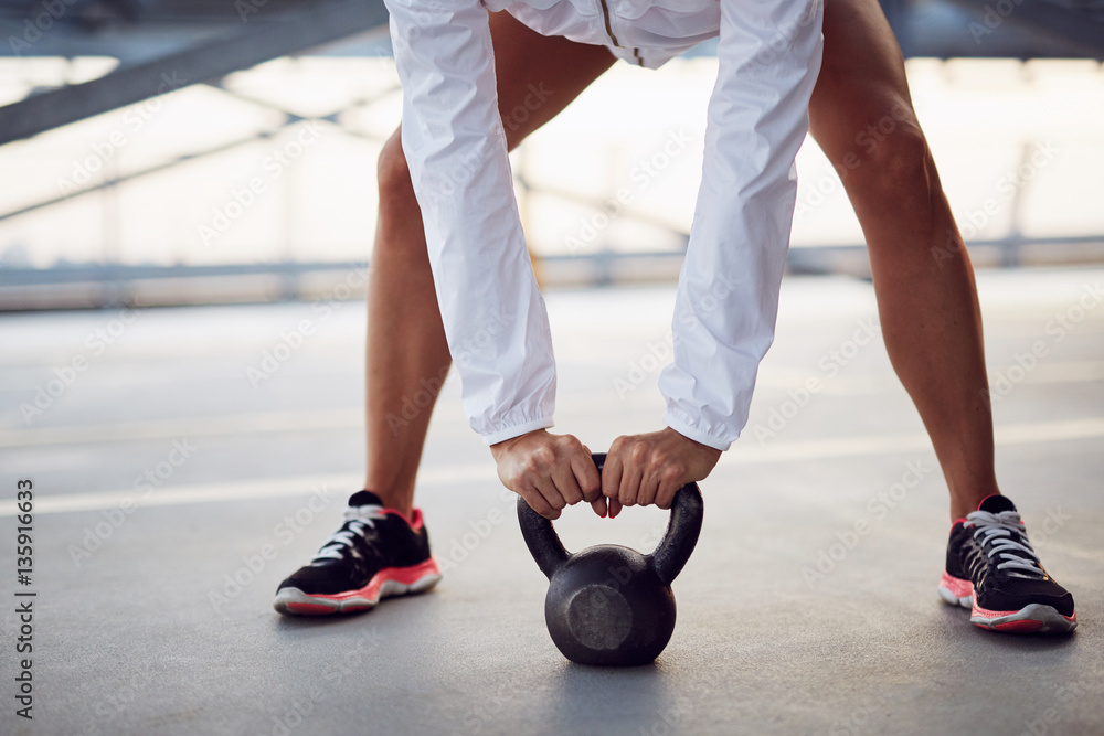 Naklejka premium Closeup of woman holding kettlebell before swing exercise