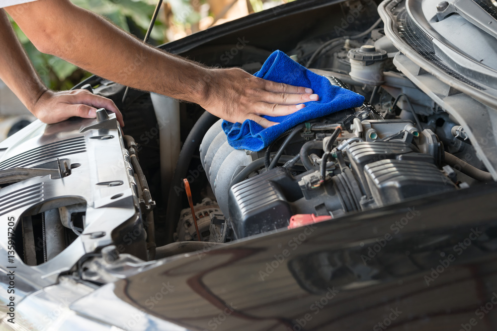 Closeup of hand cleaning car engine . Closeup of hand cleaning car engine .