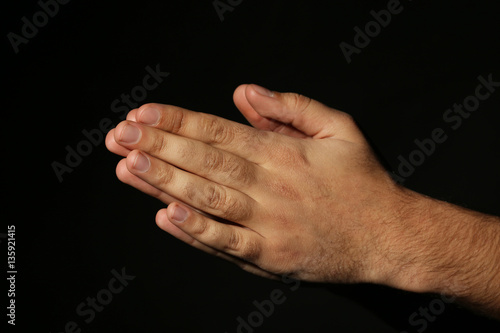 Male hands on a black background