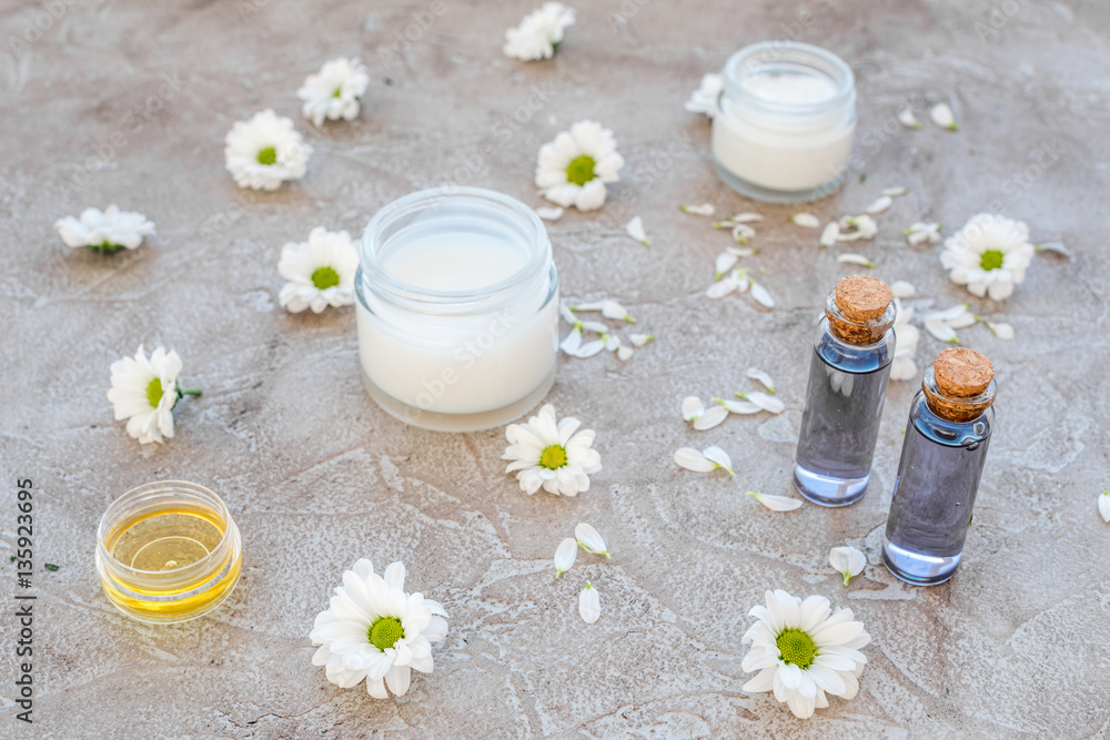 organic cosmetics with camomile on stone background