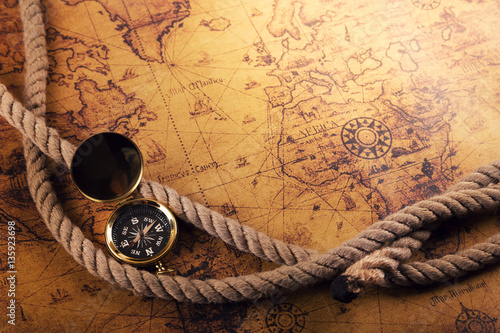 time for adventures - vintage compass and rope on old world map