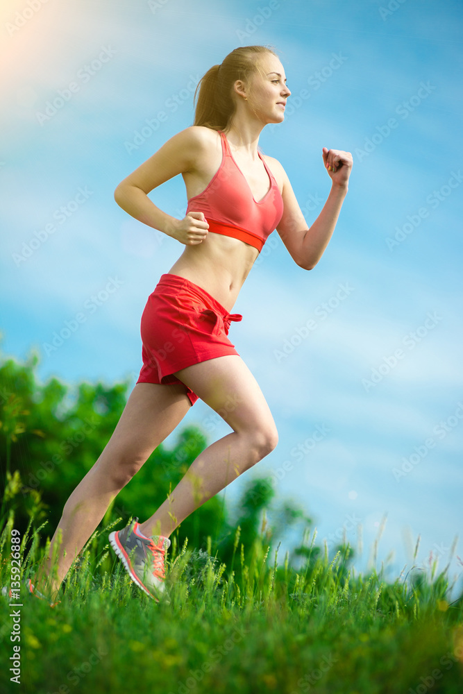 Young lady running. Woman runner running through the summer park rural road. Workout in a park. Beautiful fit girl. Fitness model caucasian ethnicity outdoors. Weight loss exercise. Jogging. Young lady running. Woman runner running through the summer park rural road. Workout in a park. Beautiful fit girl. Fitness model caucasian ethnicity outdoors. Weight loss exercise. Jogging.