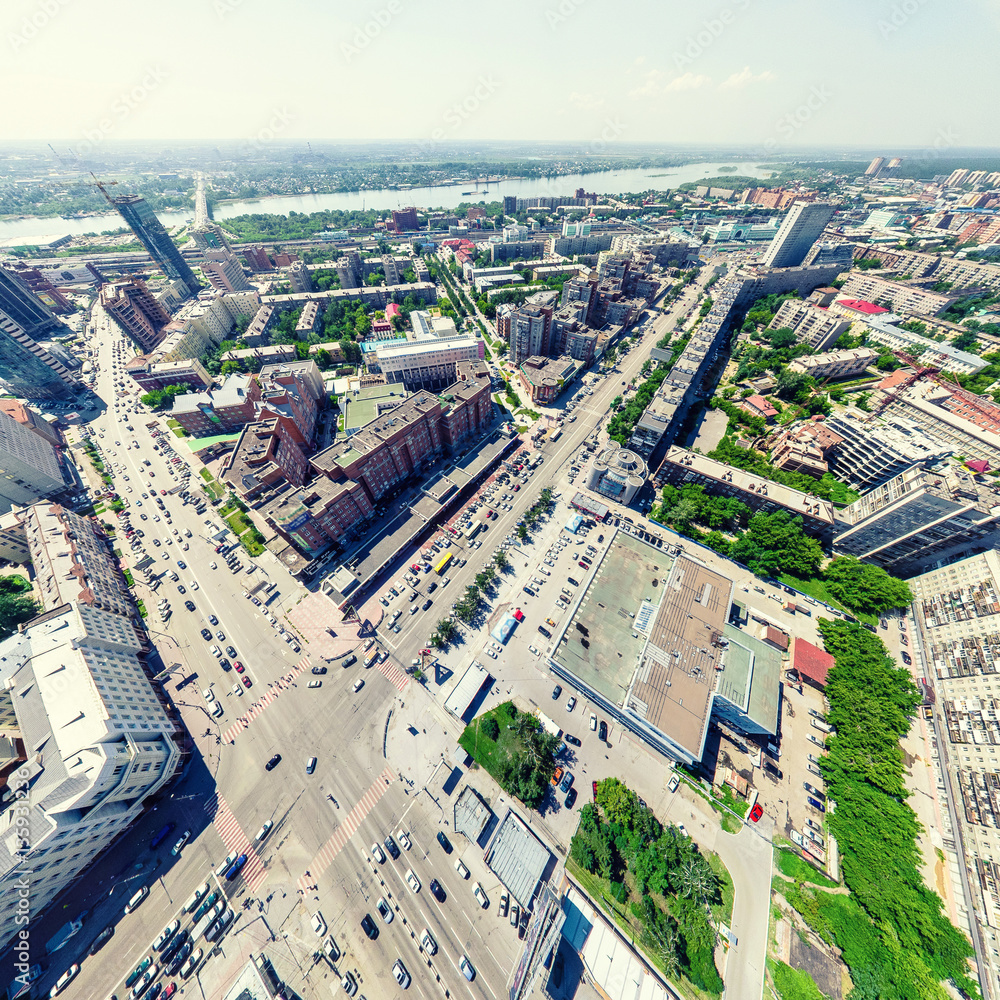 Fototapeta premium Aerial city view with crossroads and roads, houses, buildings, parks and parking lots, bridges. Urban landscape. Copter shot. Panoramic image.