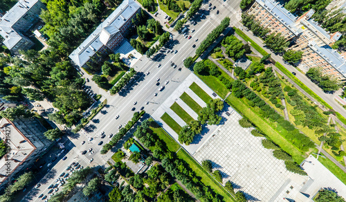 Aerial city view with crossroads, roads, houses, buildings, parks and parking lots. Copter drone helicopter shot. Panoramic wide angle image.