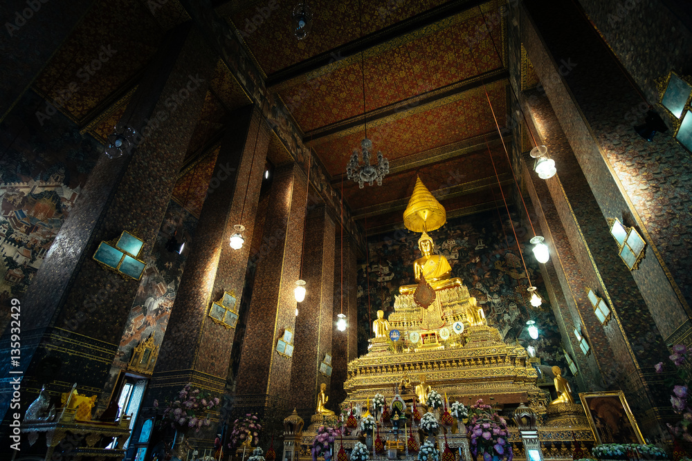 Fototapeta premium Golden Buddha sitting in Wat Pho Buddhist temple, Bangkok, Thailand. Temple of the Reclining Buddha is a famous landmark built during the first king of Thailand