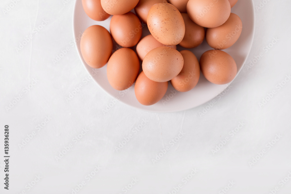 Brown eggs on a white plate on a white background. Eggs. Easter photo concept. Copyspace Brown eggs on a white plate on a white background. Eggs. Easter photo concept. Copyspace