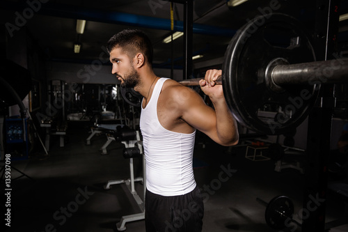 Muscular young man is working out in gym